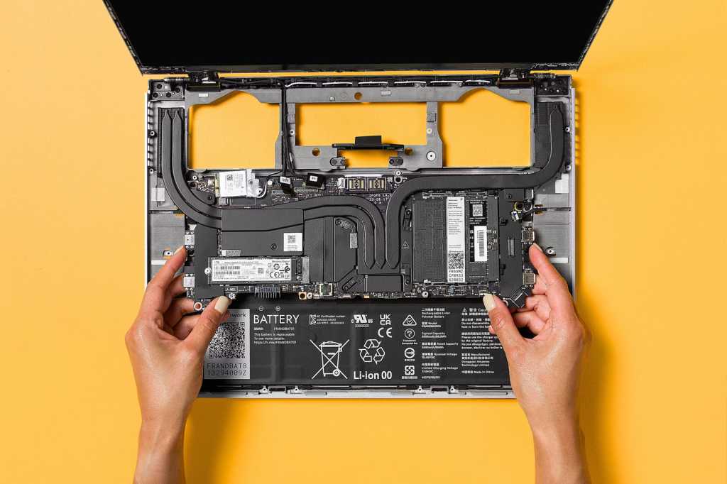 Framework Laptop With Open Internals On A Yellow Background.jpg