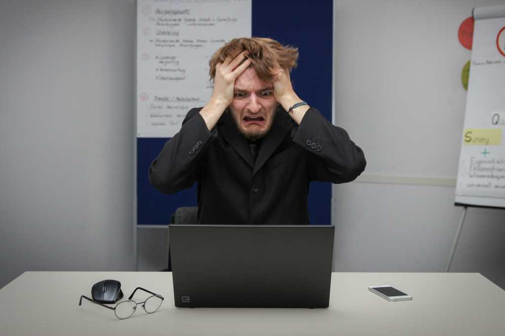 Man Frustrated By His Laptop On His Workstation At The Office 1.jpg