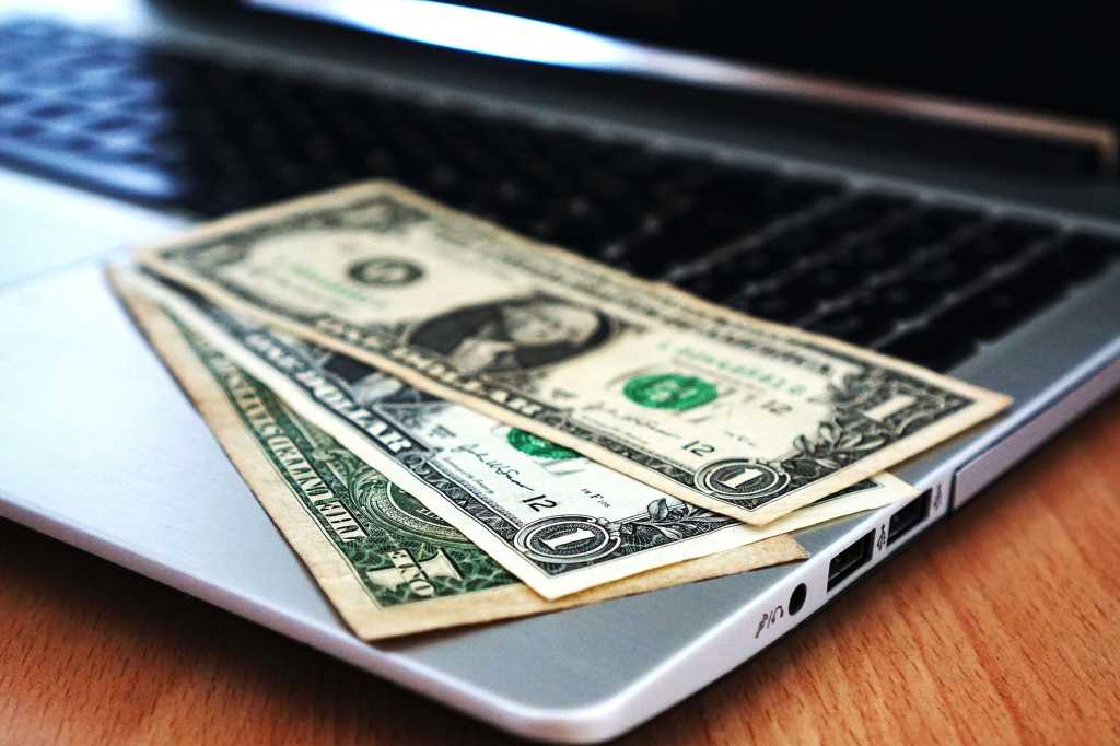 Laptop With Black Screen And Three Dollar Bills Laid Out On Keyboard.jpg